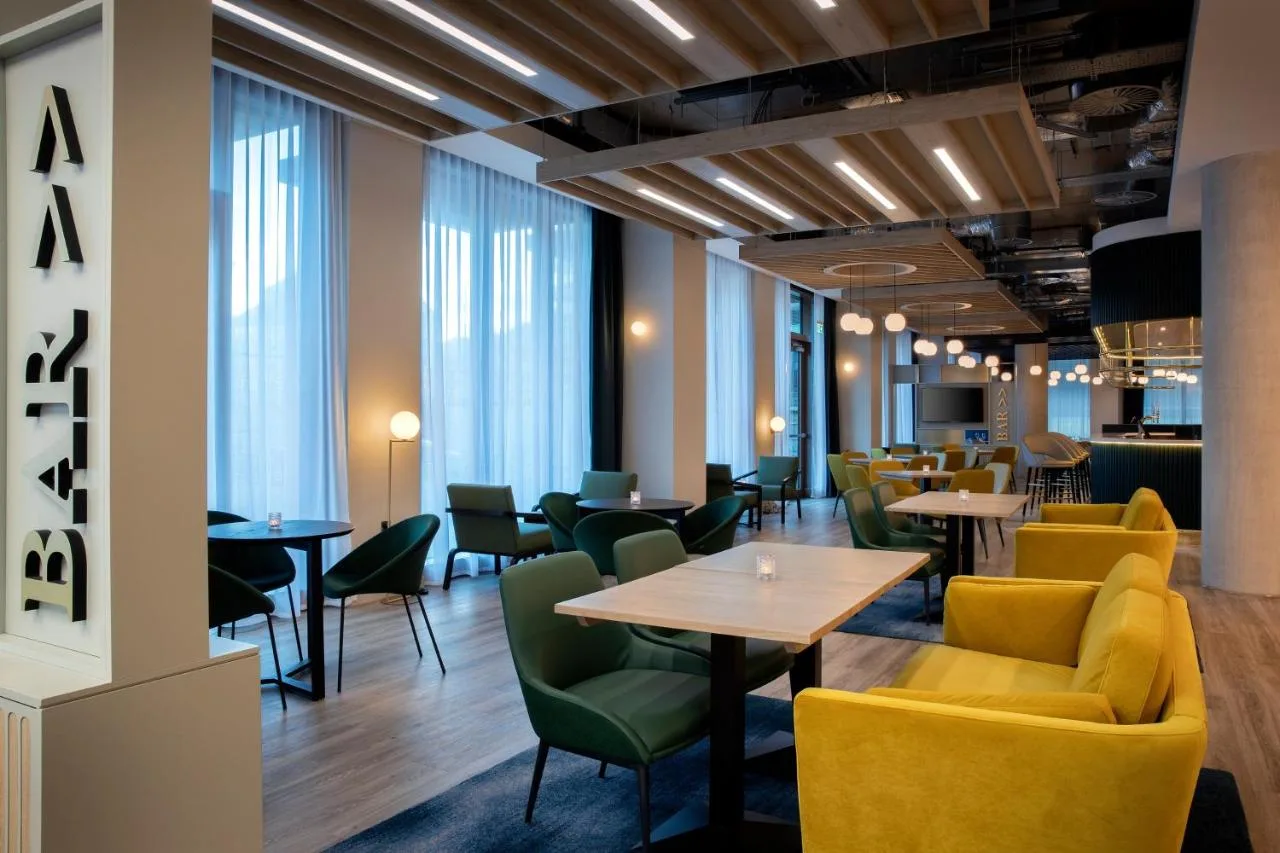 a restaurant with tables and chairs and windows at Leonardo Hotel Bristol City in Bristol