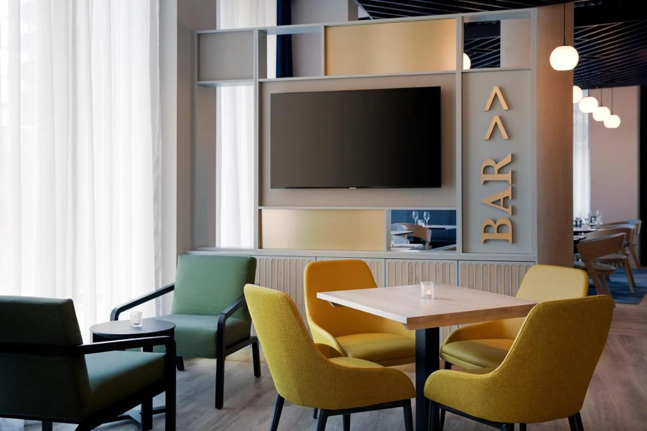 a restaurant with a table and chairs and a tv at Leonardo Hotel Bristol City in Bristol